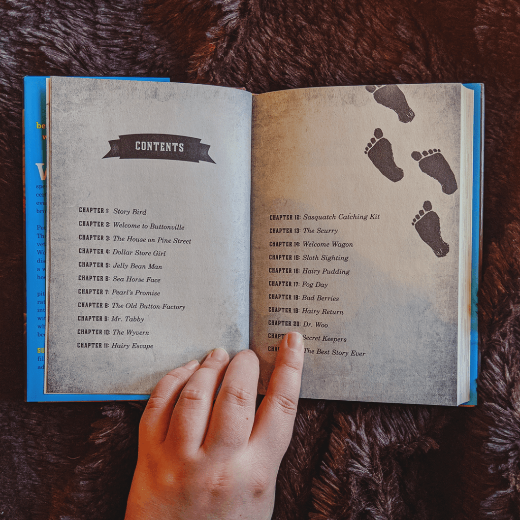 Bookstagram photo features the book THE SASQUATCH ESCAPE by Suzanne Selfors. Elza's hand holds the book open to the Contents page, which is decorated with footprints.